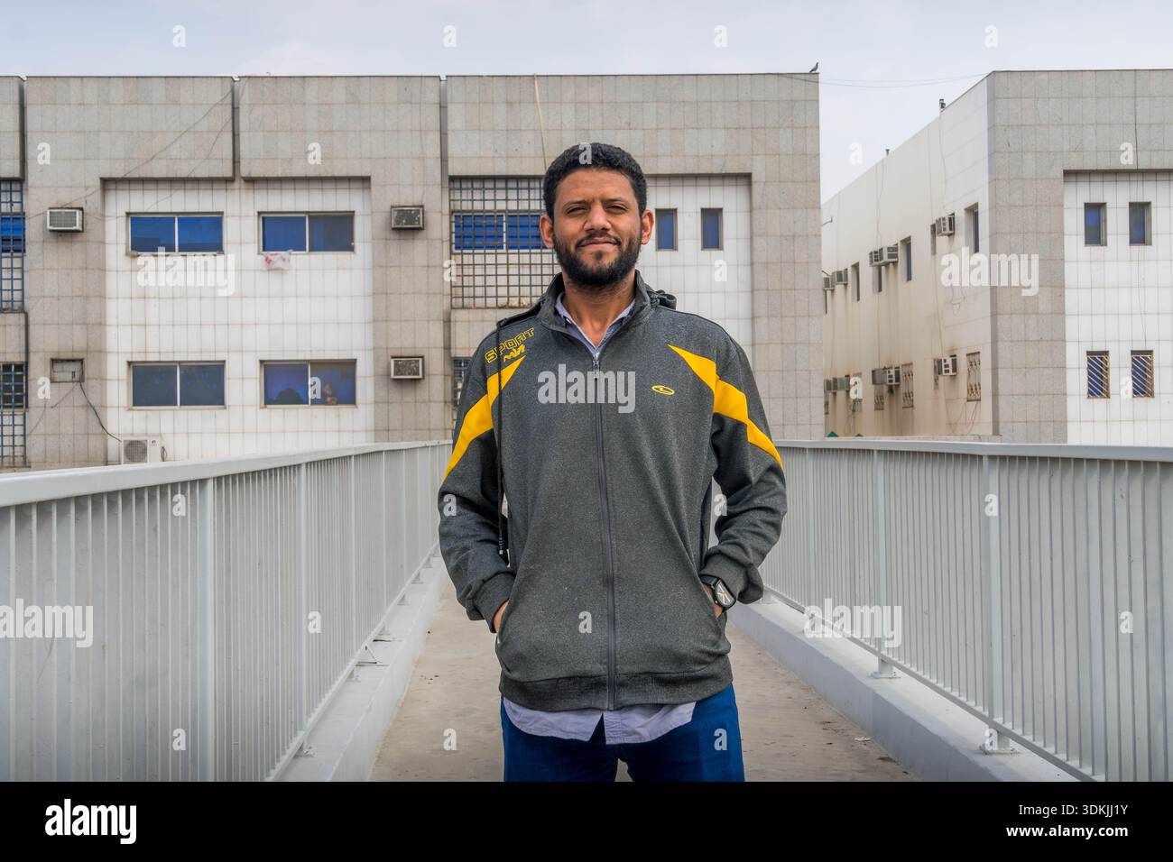 Lächelnder glücklicher Mann in grauem Hoodie auf der Straße von Riad, Saudi-Arabien. Stockfoto