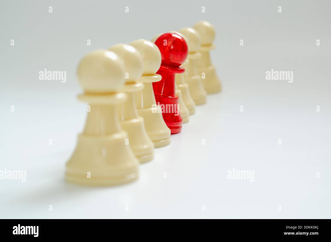 Red Pawn stieß sich von den anderen Bauern ab und repräsentierte den Mut, das Konzept zu vertreten Stockfoto