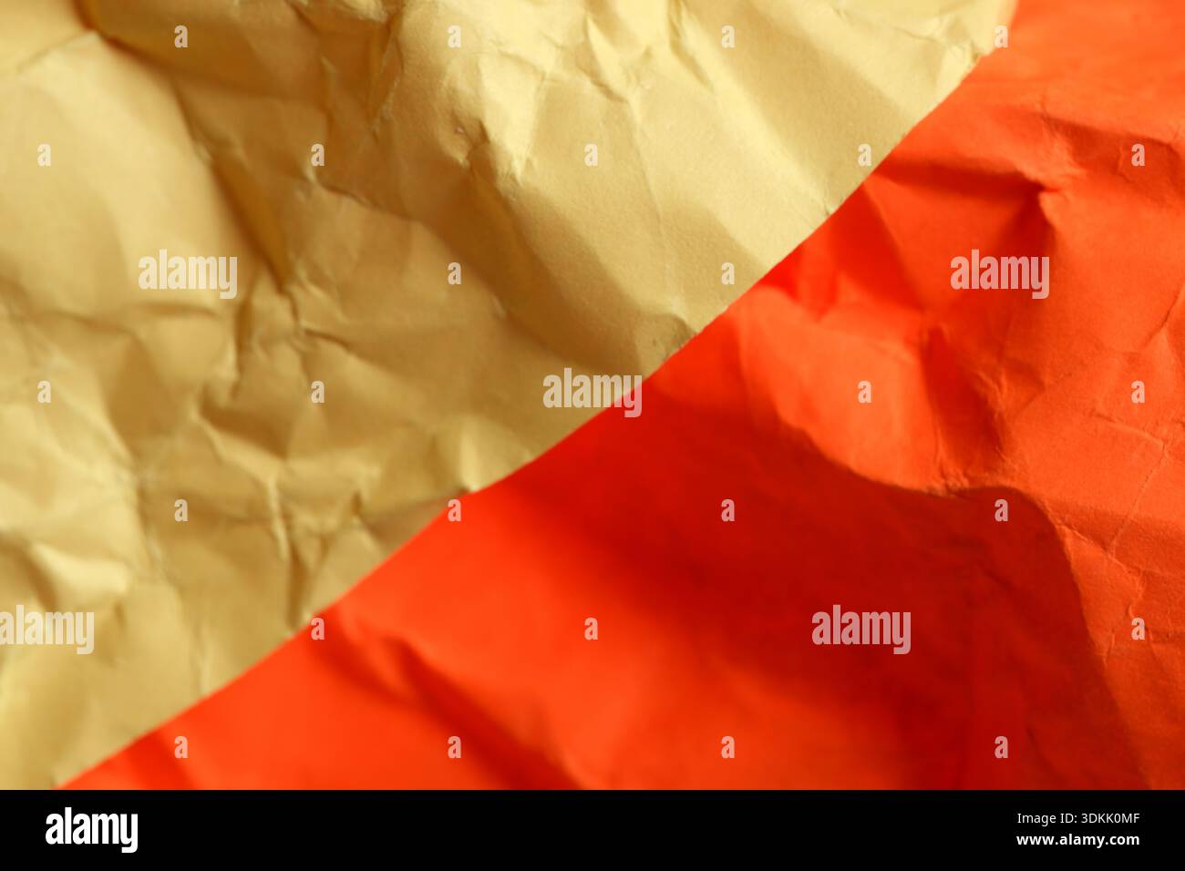 Zerknittertes Papier zeigt kräftiges Gelb und Rot und feiert lebendige Kontraste und Muster. Stockfoto