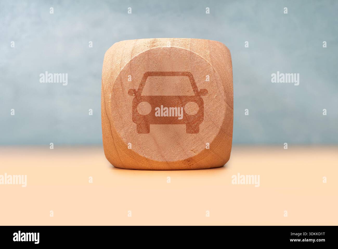 Ein Holzwürfel präsentiert ein Autosymbol und bietet ein klares, minimalistisches Transportmotiv. Perfekt für Reisen, Automobil, Logistik, Branding und Design Stockfoto