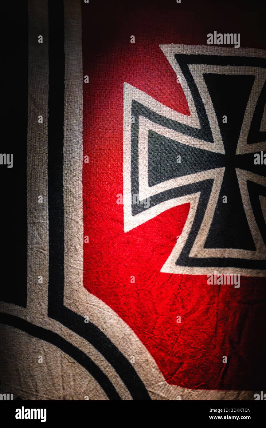 Eine Flagge zeigt das Symbol, das mit dem Nazi-Regime in Verbindung steht, in einem schwach beleuchteten Bereich Stockfoto