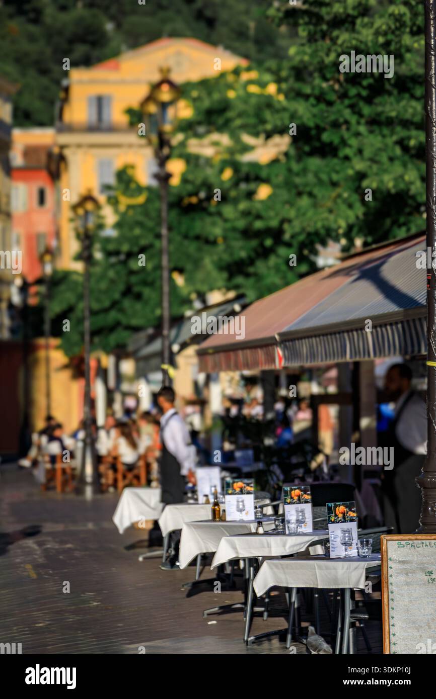 In einem Straßencafé in der Altstadt, in der Stadt Nizza, Südfrankreich, warten Tische im Freien auf die Gäste Stockfoto