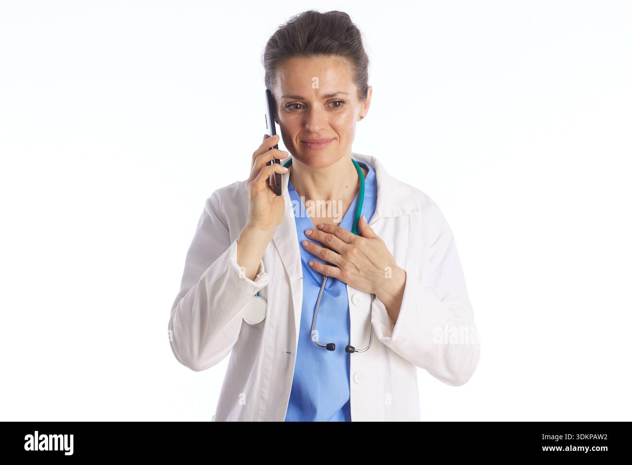 Eine mitfühlende Ärztin in Laborkittel und Stethoskop spricht auf einem Mobiltelefon und repräsentiert die Patientenfernbetreuung und klinische Kommunikation. Stockfoto