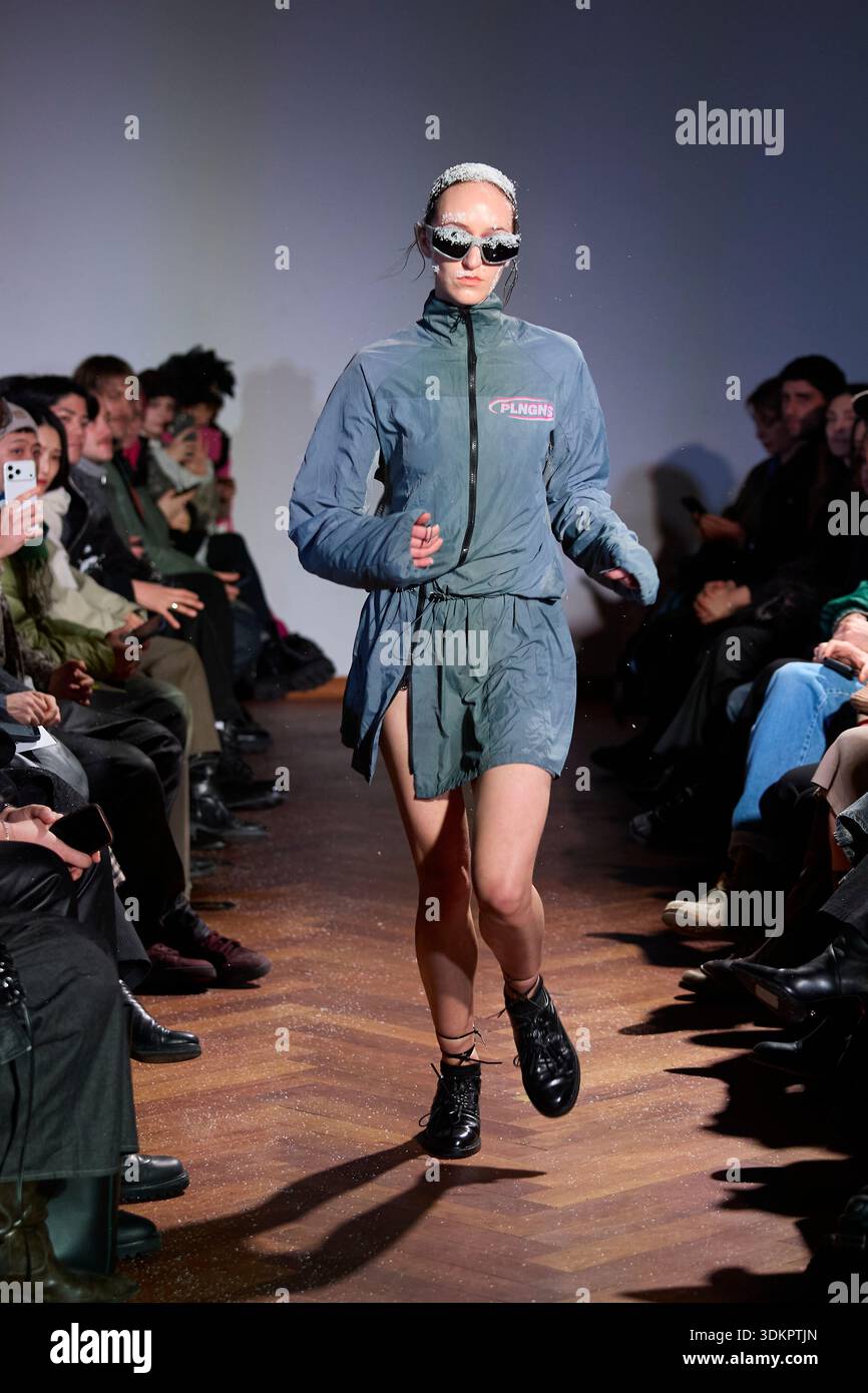 Berlin, Deutschland, 2. Februar 2026. Ein weibliches Model läuft in einem futuristischen Tech-Wear-Look auf der PLNGNS AW26 Show während der Berlin Fashion Week über den Laufsteg. Das Outfit wurde als Teil der „ERROR AS ASSET“-Kollektion präsentiert und verfügt über eine taillierte Jacke mit hohem Reißverschluss aus reflektierendem graublauem technischen Material mit rosafarbenem Logo, dazu passende, lose Shorts an der Taille, eine auffällige Sonnenbrille und schwarze Stiefel. Quelle: Felix Wolf/Alamy Live News Stockfoto