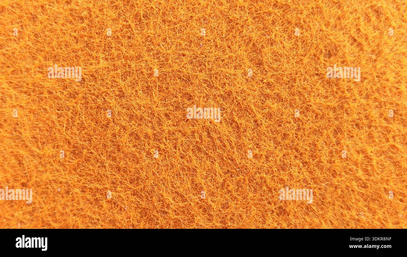 Abstrakter Makrohintergrund der orangefarbenen Textur der synthetischen Faser-Oberfläche Stockfoto