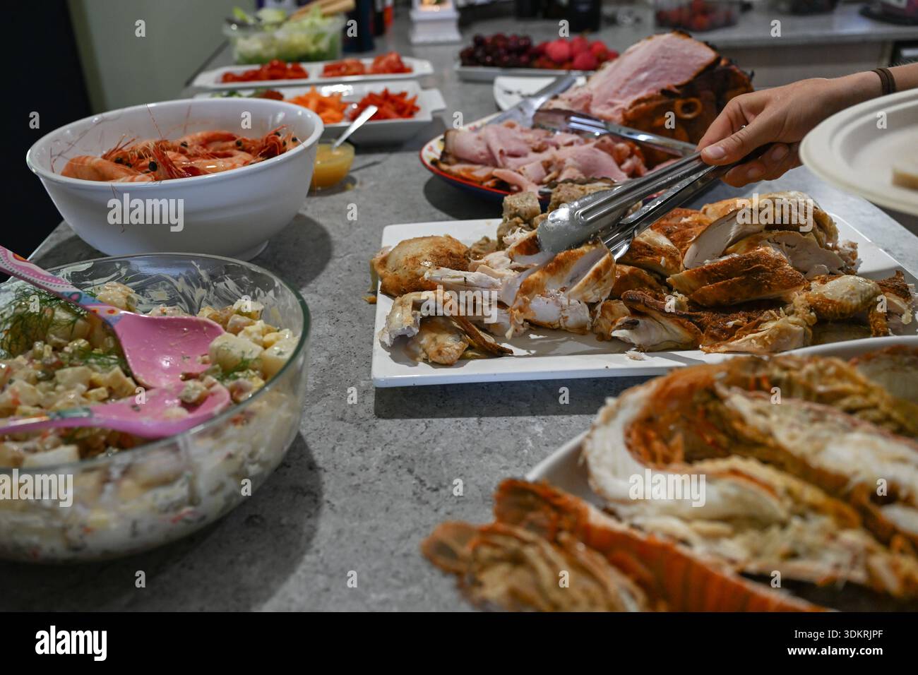 Weihnachtliches Mittagessen in Australien, authentisches Familienessen auf der Küchenbank, Salat mit Meeresfrüchten und Aufschnitt Stockfoto