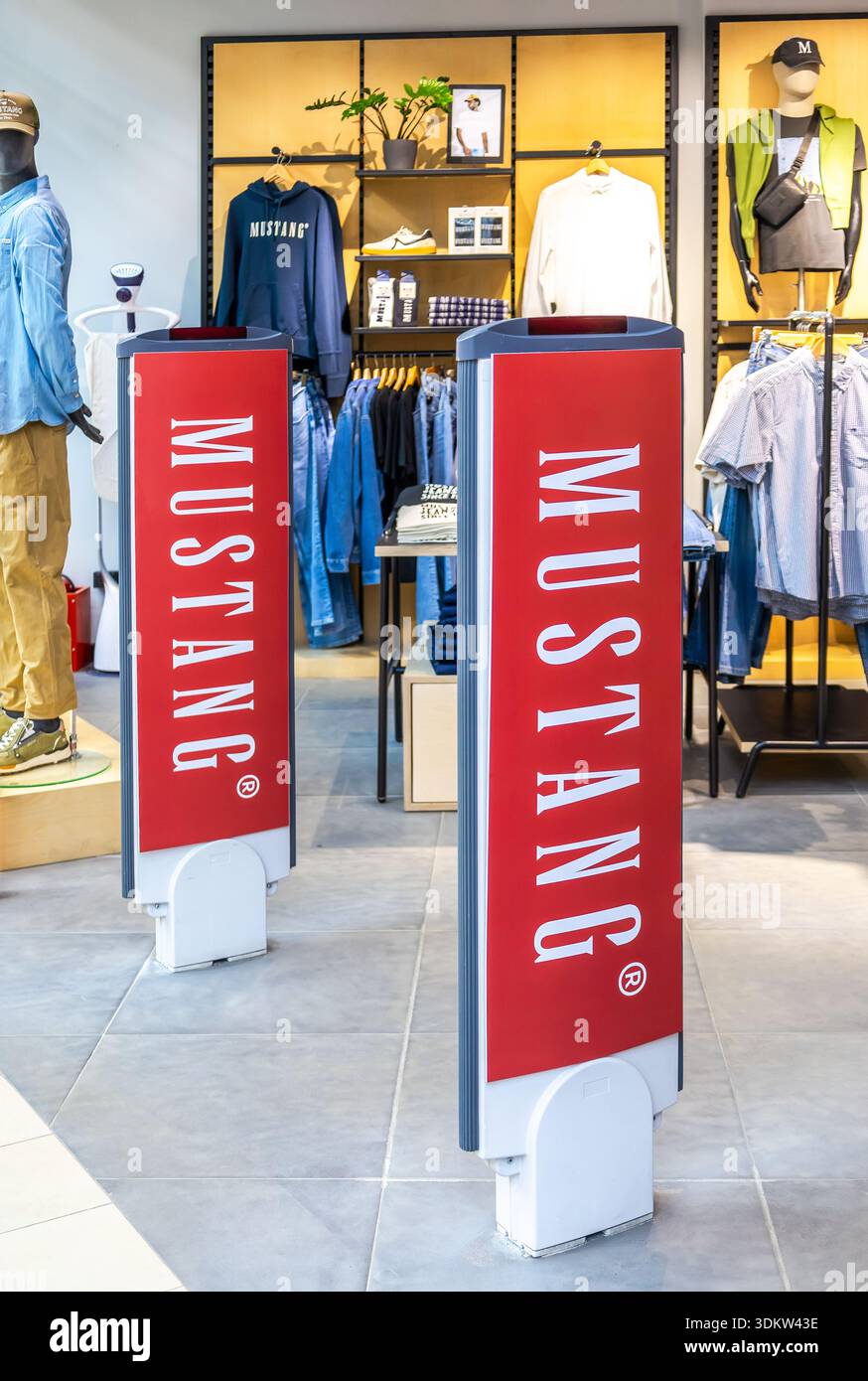 Samara, Russland - 19. April 2025: Am Eingang einer Bekleidungsboutique stehen Schilder für Mustang-Geschäfte. Mustang ist eine Jeans- und Lifestyle-Marke Stockfoto