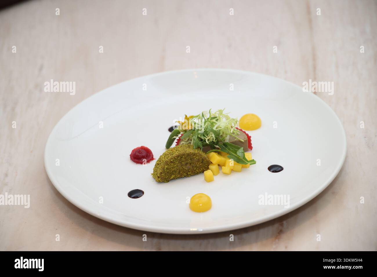 Gourmet-Vorspeise kunstvoll auf weißem Teller angeordnet, mit einer raffinierten Mischung aus Farben, Texturen und Zutaten, die einen raffinierten Stil darstellen Stockfoto