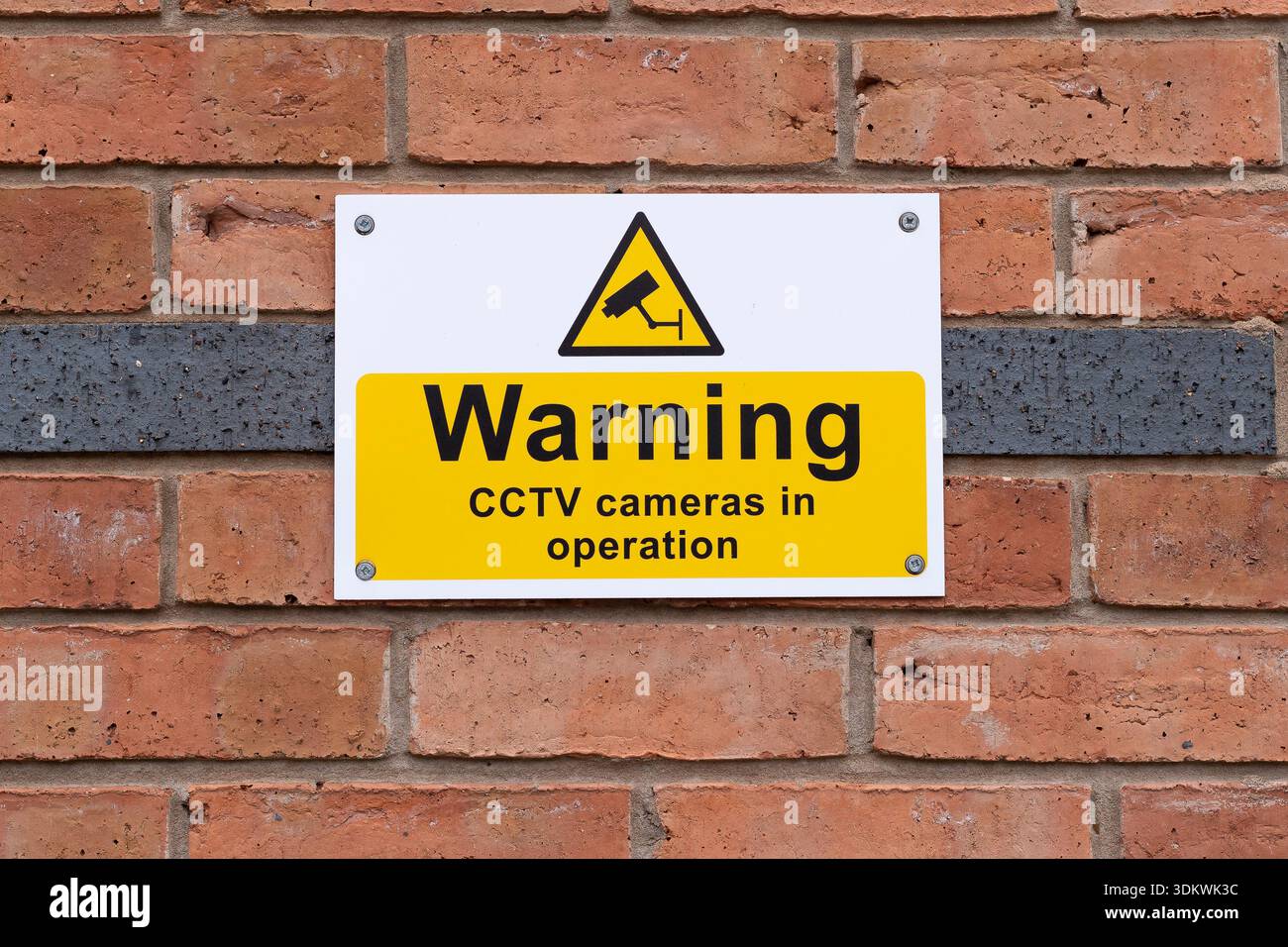 Nahaufnahme eines isolierten Schilds an der Außenwand, das die britische Öffentlichkeit informiert: In diesem Bereich sind CCTV-Kameras im Einsatz. Stockfoto