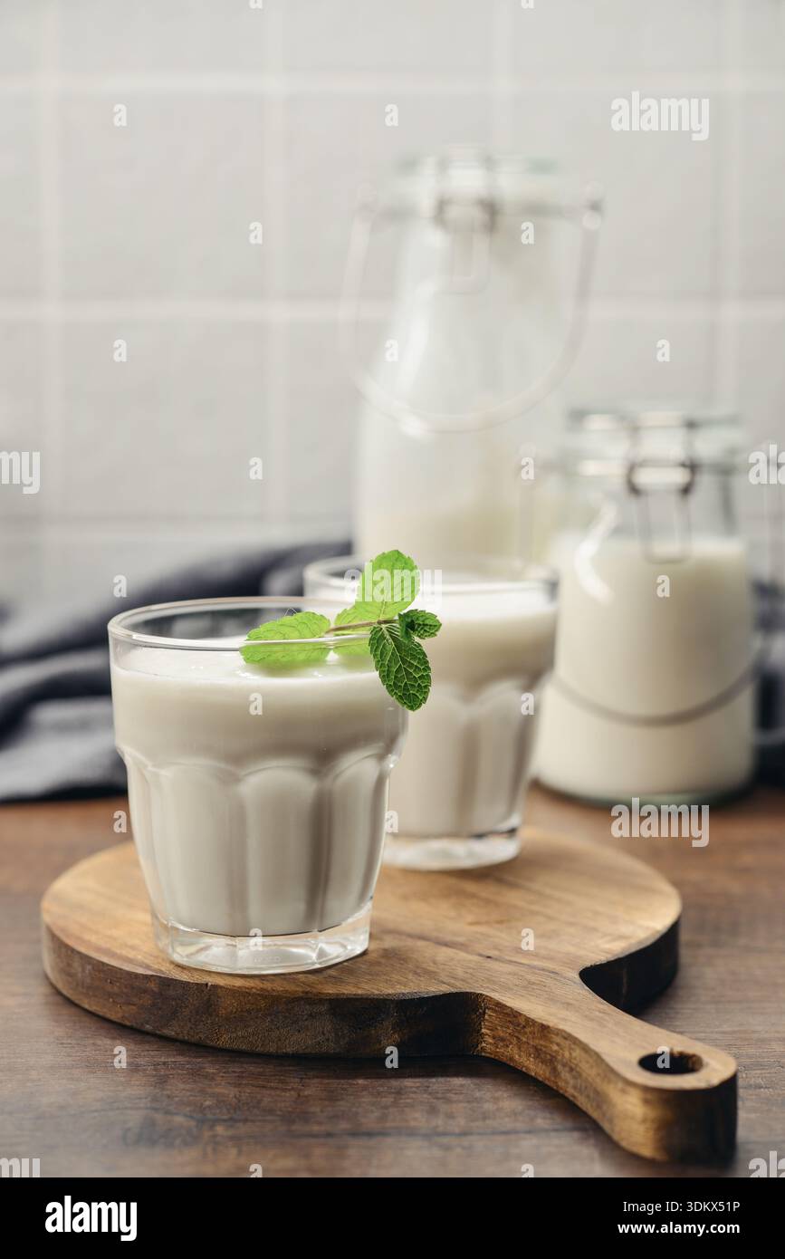 Zwei Gläser traditionelles türkisches Getränk Ayran, Kefir oder Buttermilch, hausgemachter einfacher Joghurt aus nächster Nähe auf Holztisch Stockfoto