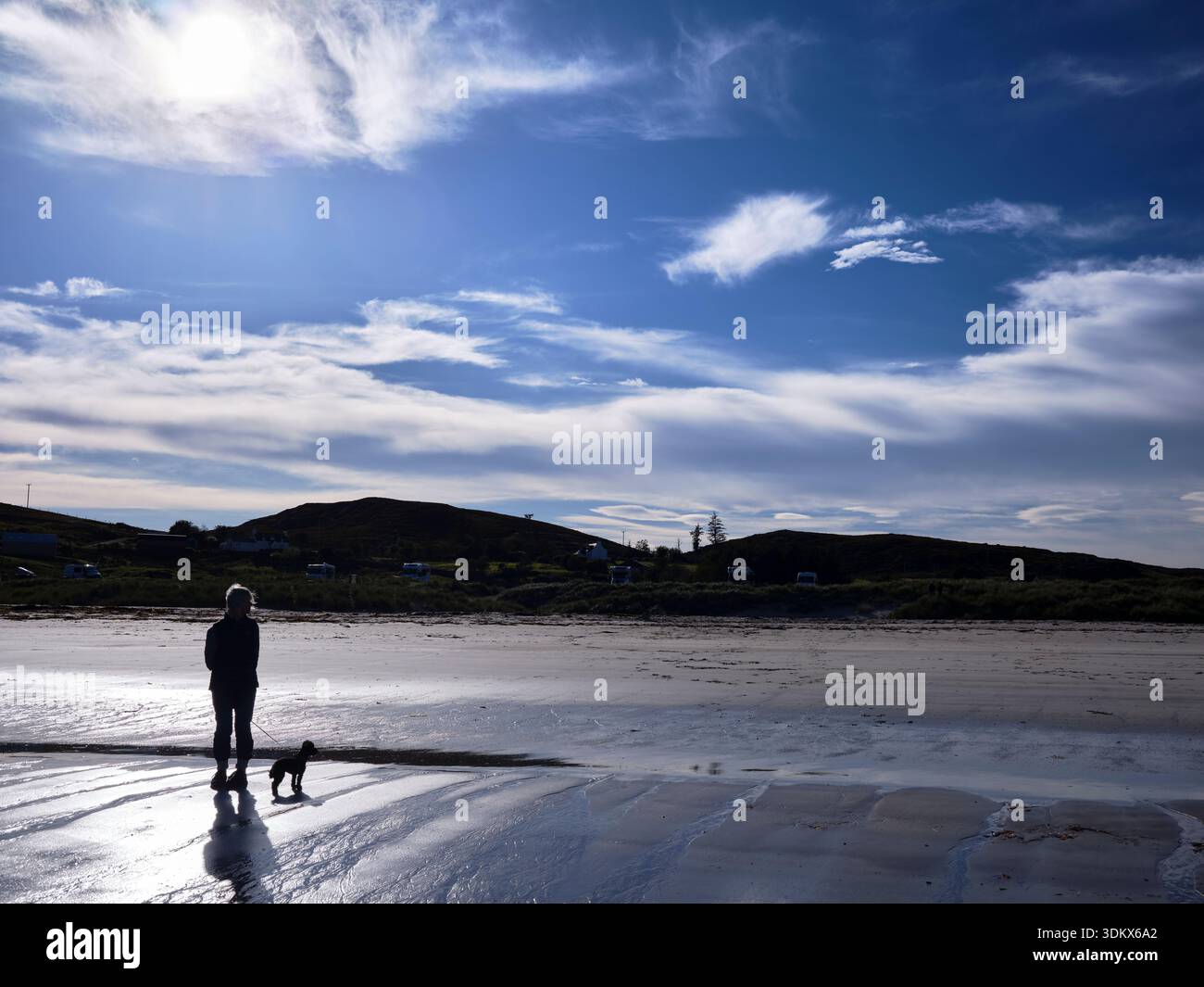 Mellon Udrigle, Ross-shire, Schottland, Vereinigtes Königreich. September 2025. Ein einsames Weibchen tränkt sich in der Einsamkeit, während sie mit ihrem Hund am Strand von Mellon Udrigle spaziert Stockfoto