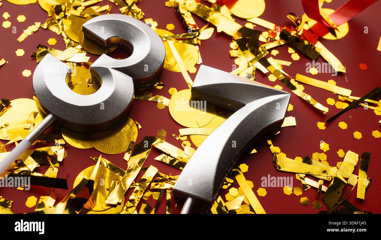 Nummer 37 Geburtstagsziffer auf rotem fest mit Konfetti-Hintergrund. Siebenunddreißig Jahre Geburtstag. Konzept von Geburtstag, Jubiläum und Datum. c Stockfoto