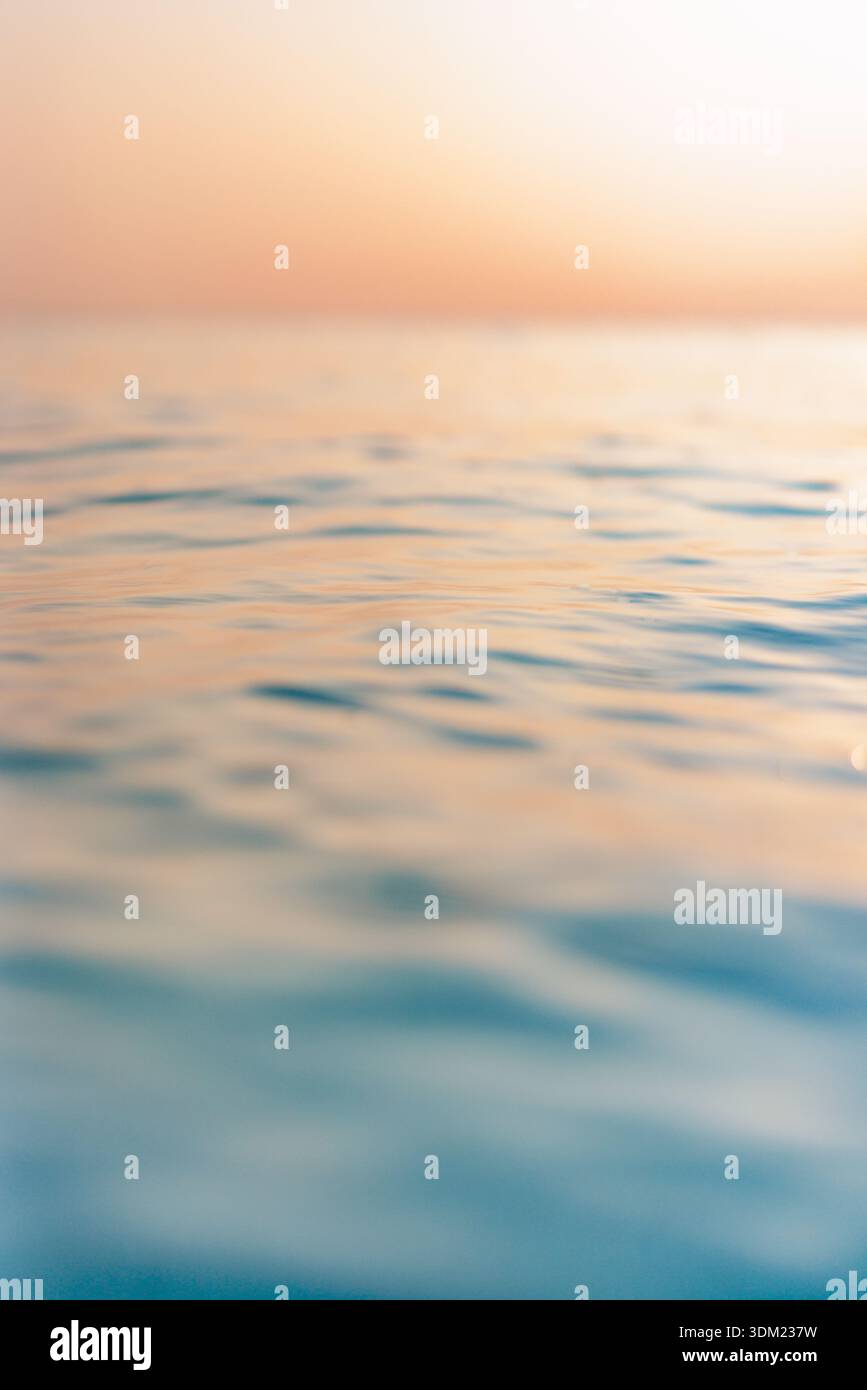Atemberaubender ruhiger Ozean sanfter goldener Sonnenuntergang minimaler Horizont traumhafte ruhige ruhige Meereslandschaft warmes Pastell-Glühen friedliche Meditationskulisse Stockfoto