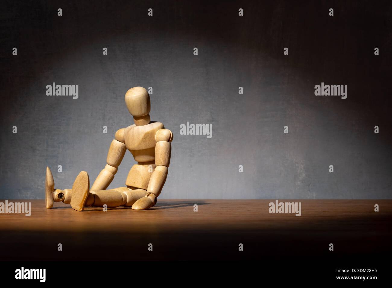 Eine hölzerne Puppe sitzt in einer besiegten Haltung. Depression, Burnout, Einsamkeit, Müdigkeit, psychische Gesundheit kämpft Konzept. Kopierbereich für Text. Stockfoto