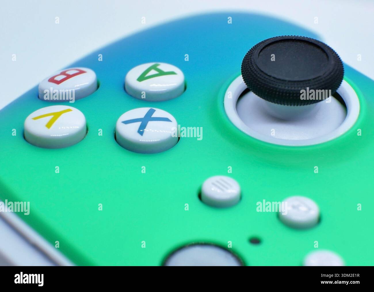 Makroaufnahme mit bunten Tasten für den Gamecontroller und dem analogen Joystick. Moderne Gaming-Technologie für E-Sport, Videospiele, Unterhaltung und Stockfoto