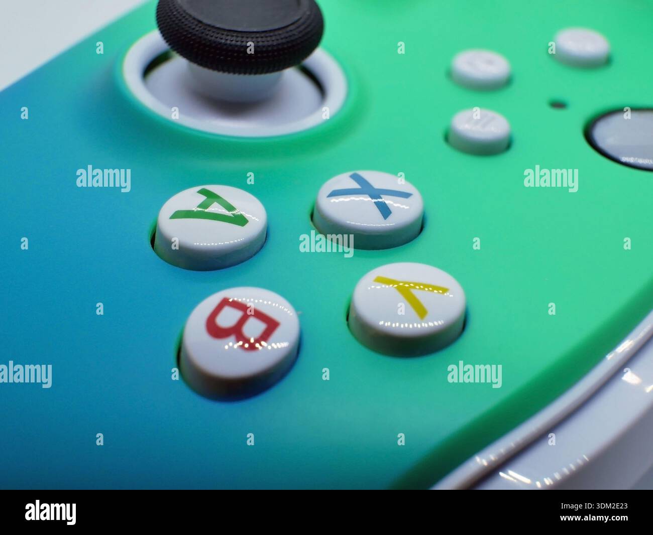 Makroaufnahme mit bunten Tasten für den Gamecontroller und dem analogen Joystick. Moderne Gaming-Technologie für E-Sport, Videospiele, Unterhaltung und Stockfoto