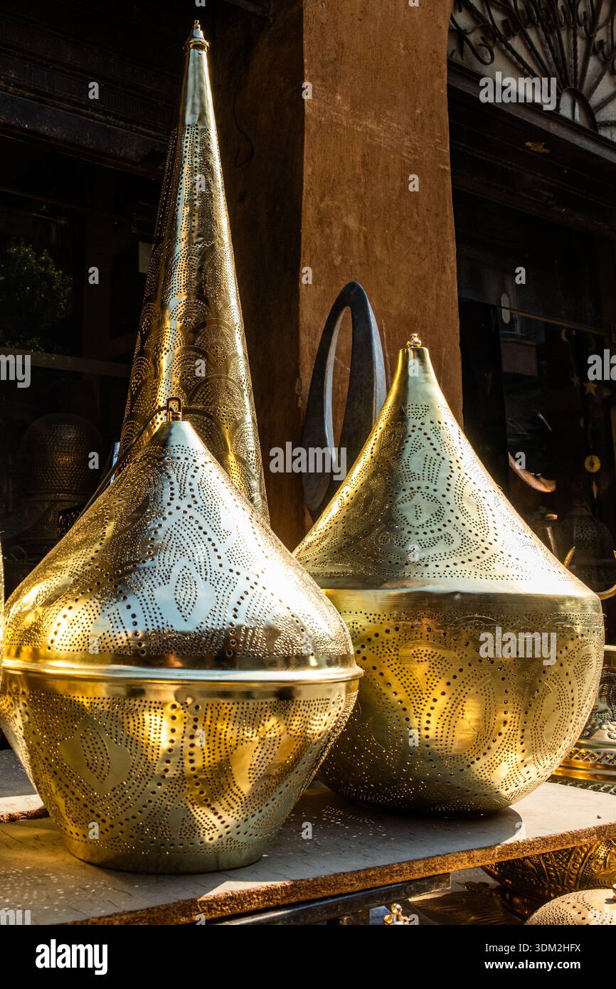 Kunstvoll verzierte Tischleuchten aus Messing, die auf einem Markt ausgestellt werden. Verschiedene Formen und Größen, die traditionelle ägyptische Handwerkskunst widerspiegeln. Ideal für Ramadan-Dekor. Stockfoto