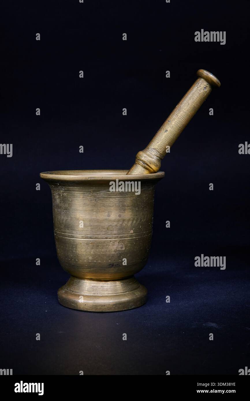 Ein alter Messingmörtel und -Pissel. Auf schwarzem Hintergrund. Anwendung der Lichtmaltechnik. Stockfoto