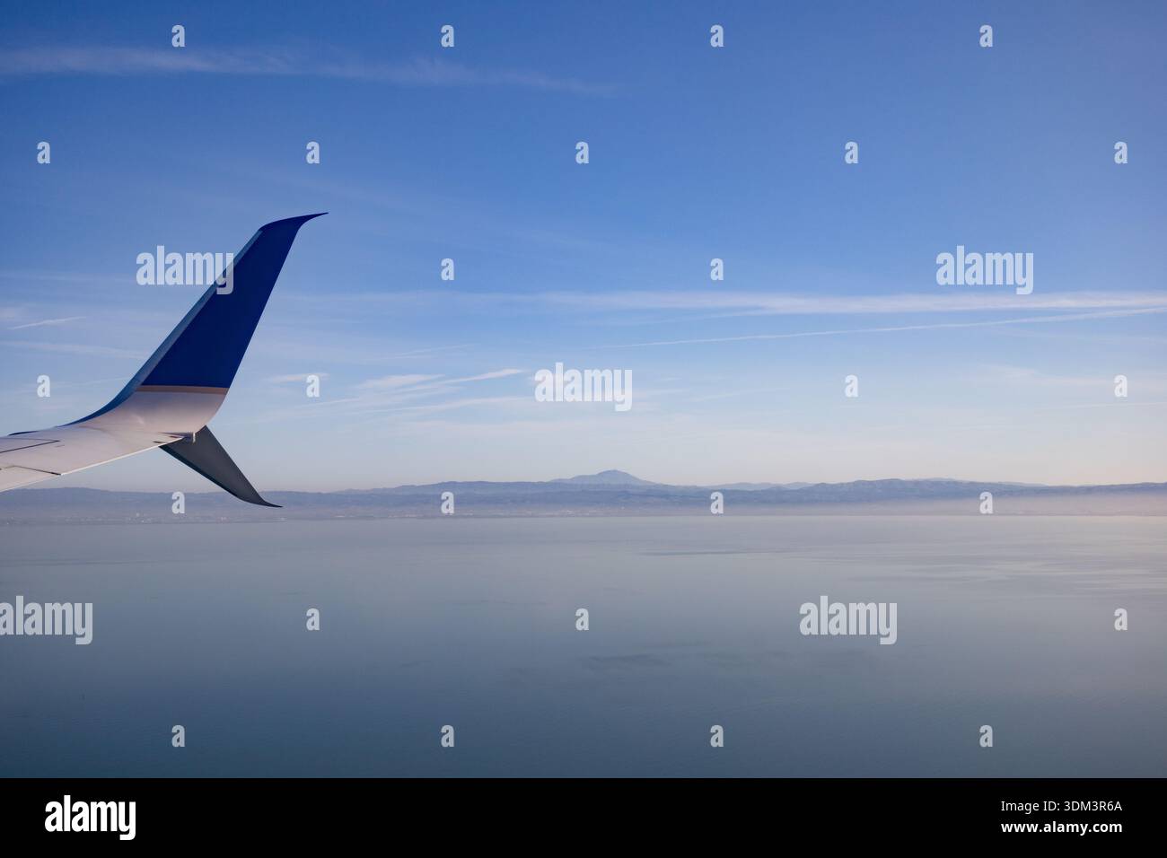 Blick auf ein Winglet der United Airlines Boeing 737, das über einem riesigen blauen Himmel und Ozean schwingt, während des Fluges aus einem Passagierfenster aufgenommen. Stockfoto