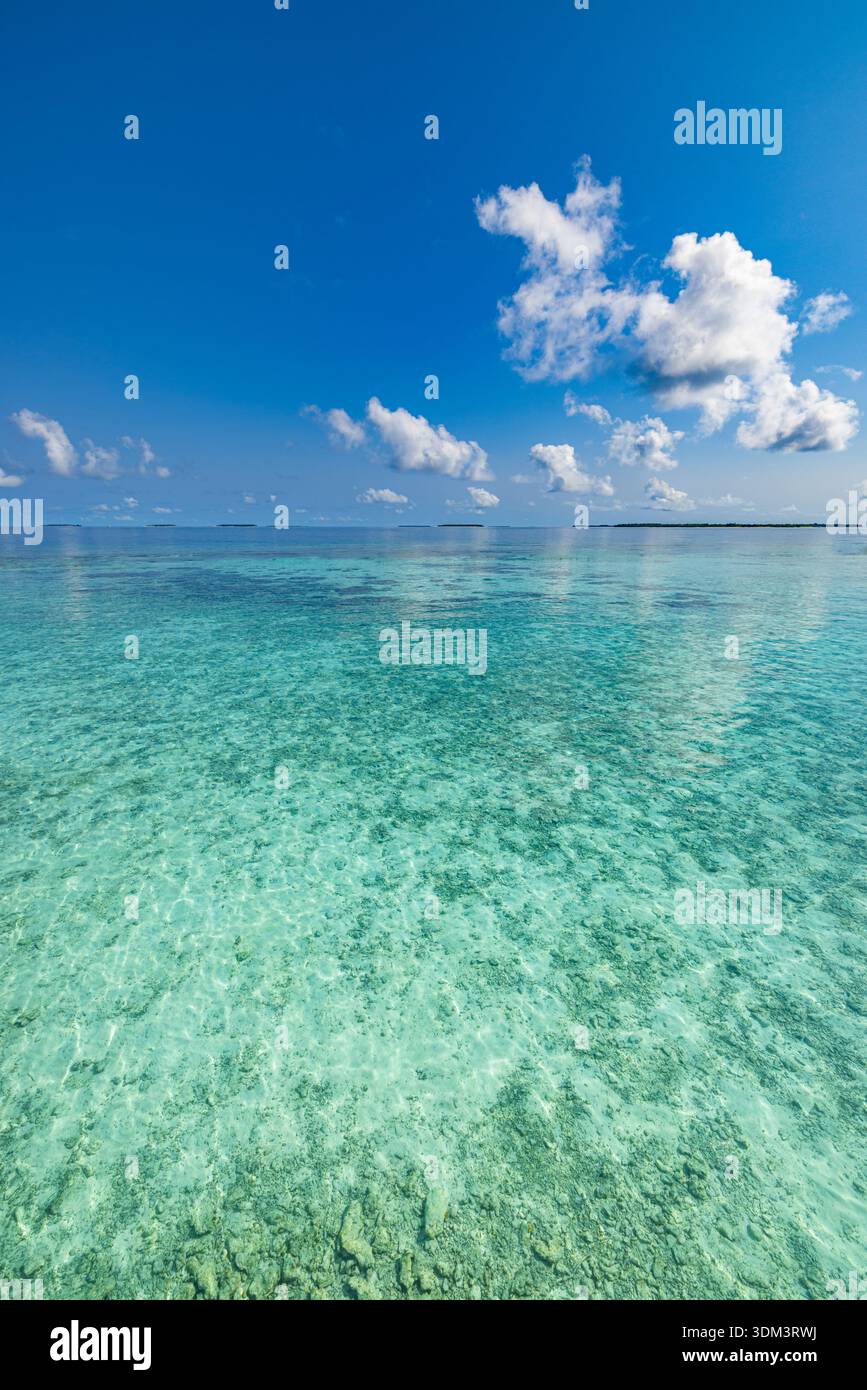 Sonniger Meerblick entspannend ruhiges Wasser szenischer Horizont glücklicher blauer Himmel flauschige weiße Wolken tropisches Meerparadies Sommerreise vertikaler Hintergrund Stockfoto