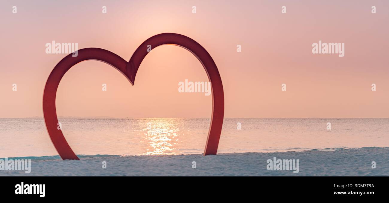 Romantische Herzform im Strand Sand mit leuchtendem Ozean Sonnenuntergangshorizont farbenfroher Himmel friedliche Wellen Sommer Flitterwochen Reise Hintergrund Stockfoto