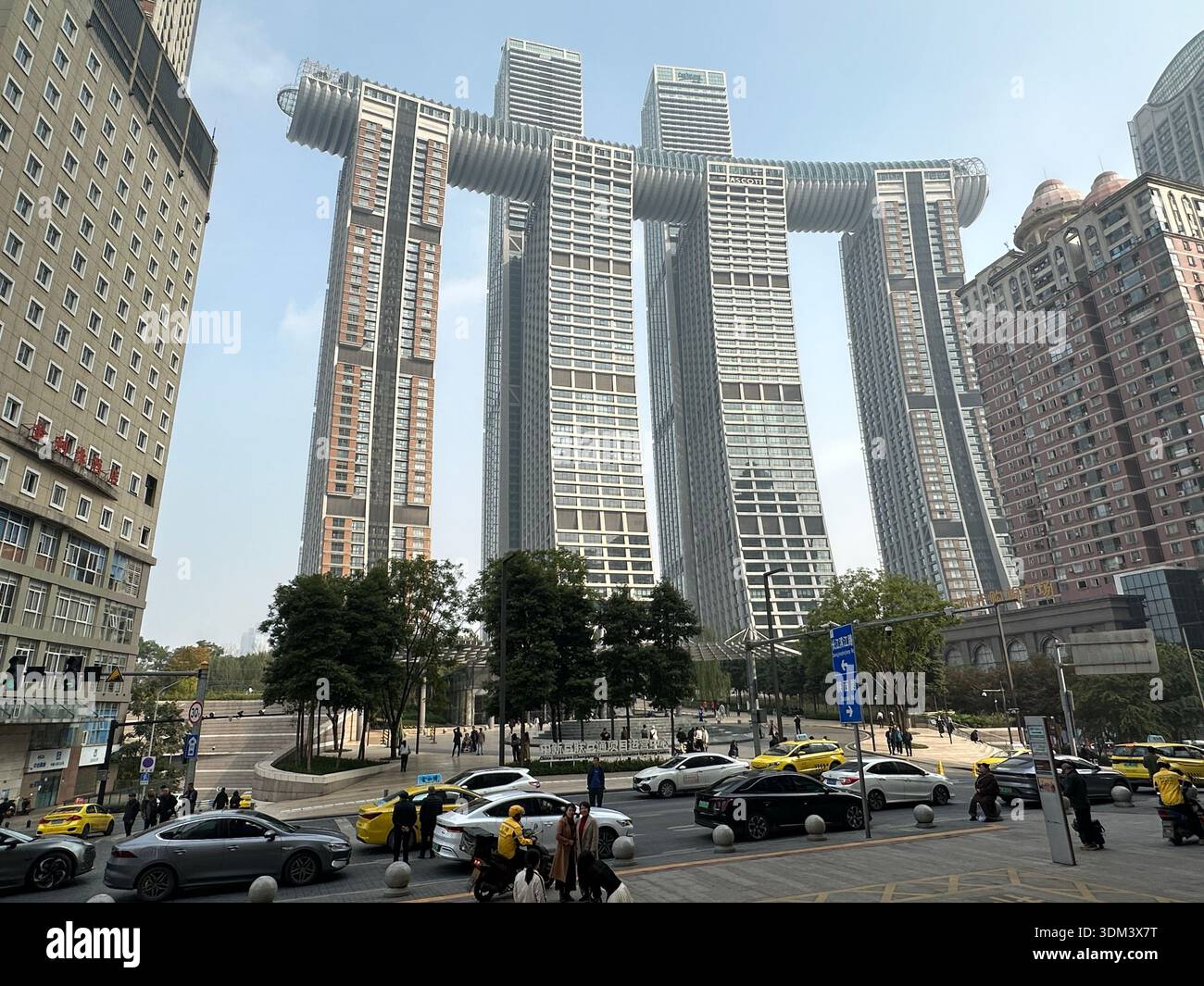 Chongqing, China - 6. Dezember 2023: Ascott Hotel in Chongqing, China, mit einzigartiger Architektur und geschäftiger Straße darunter. Stockfoto