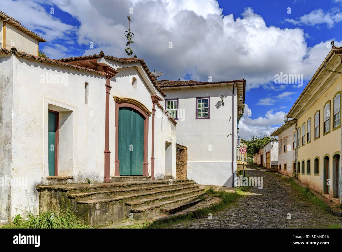 Historische Kapelle auf einer kopfsteingepflasterten Straße und alte Kolonialhäuser in Ouro Preto, Ouro Preto, Minas Gerais, Brasilien Stockfoto
