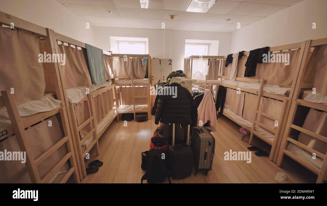 Hostel Schlafsaal mit mehreren Etagenbetten und Gepäck, bietet preisgünstige Unterkunft für Reisen Stockfoto