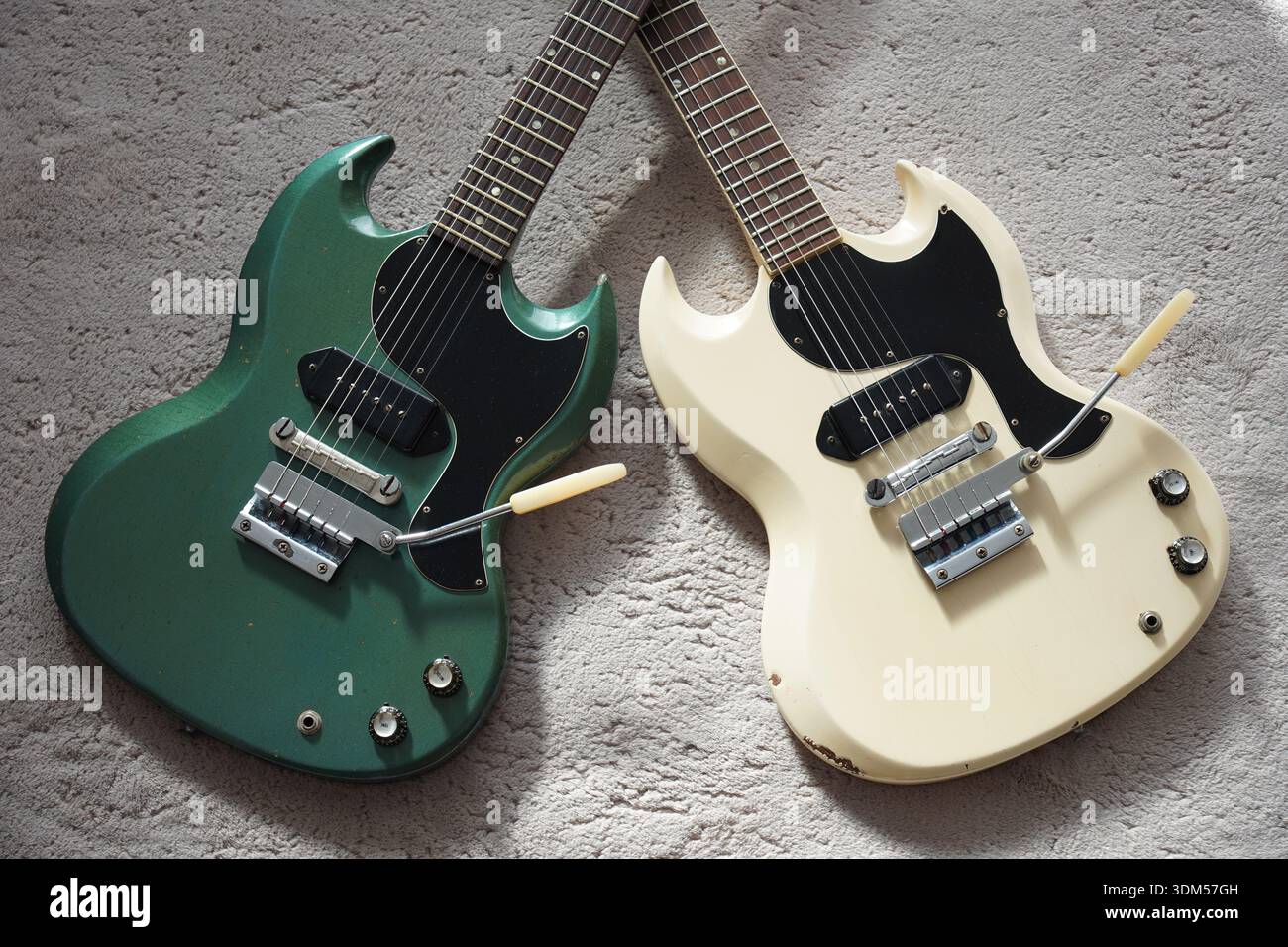 Zwei seltene Vintage-Gitarren auf einem Teppich in X-Form Stockfoto