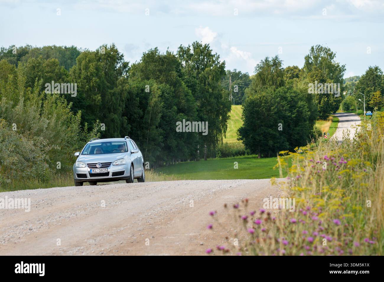 LETTLAND, VALDEMARPILS - 28. JULI: Fast die Hälfte des lettischen nationalen Straßennetzes ist abgeschottet. Auto auf einer Schotterstraße 28.07.2023, Valdemarpils, Lettland. Stockfoto