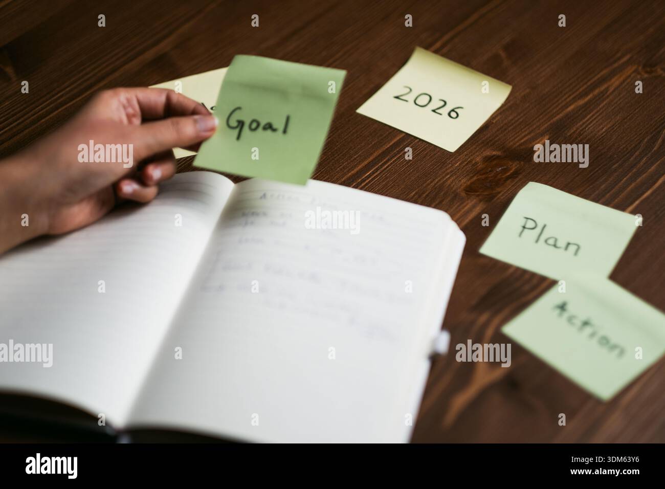 Handschrift von Zielen in Notizbuch mit Haftnotizen für Plan und Aktion für 2026 Stockfoto