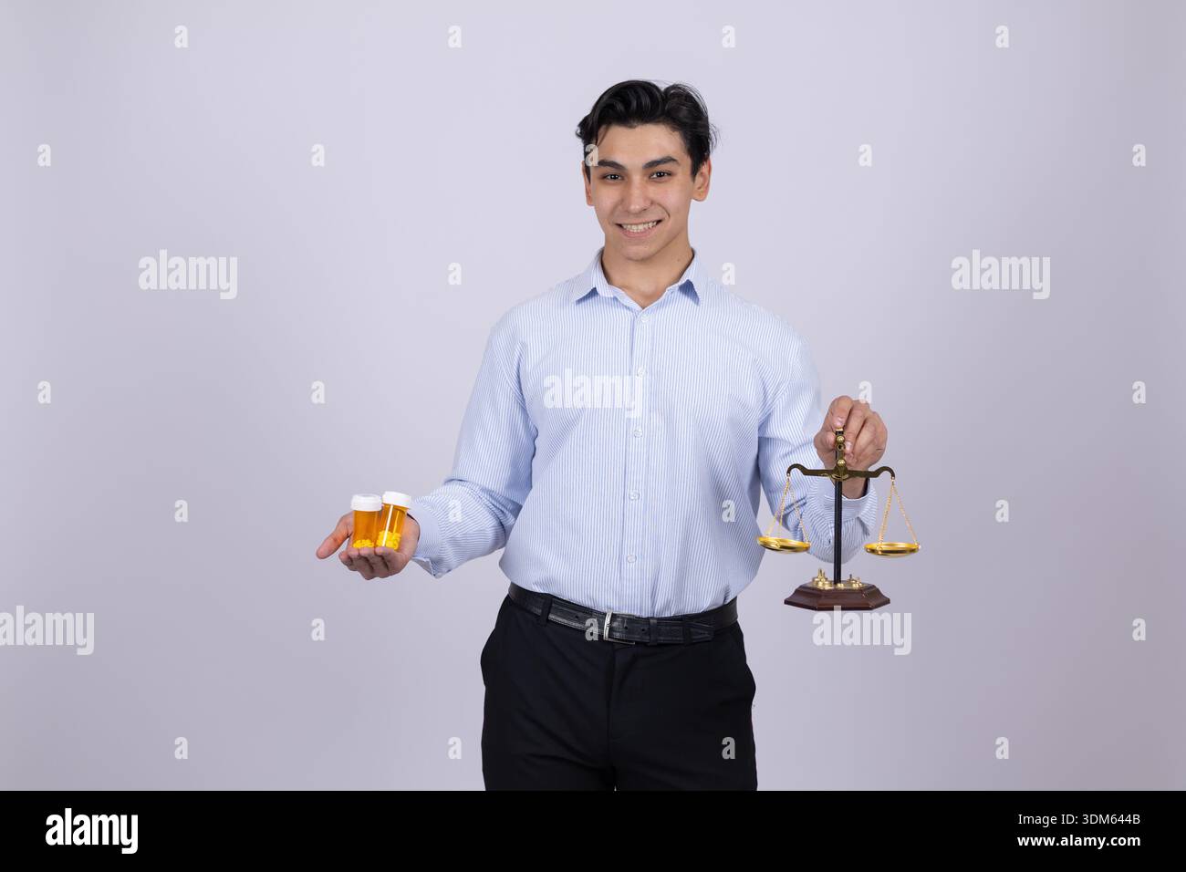 Junger Mann in weißem Hemd mit orangefarbener und medizinischer Waage Stockfoto