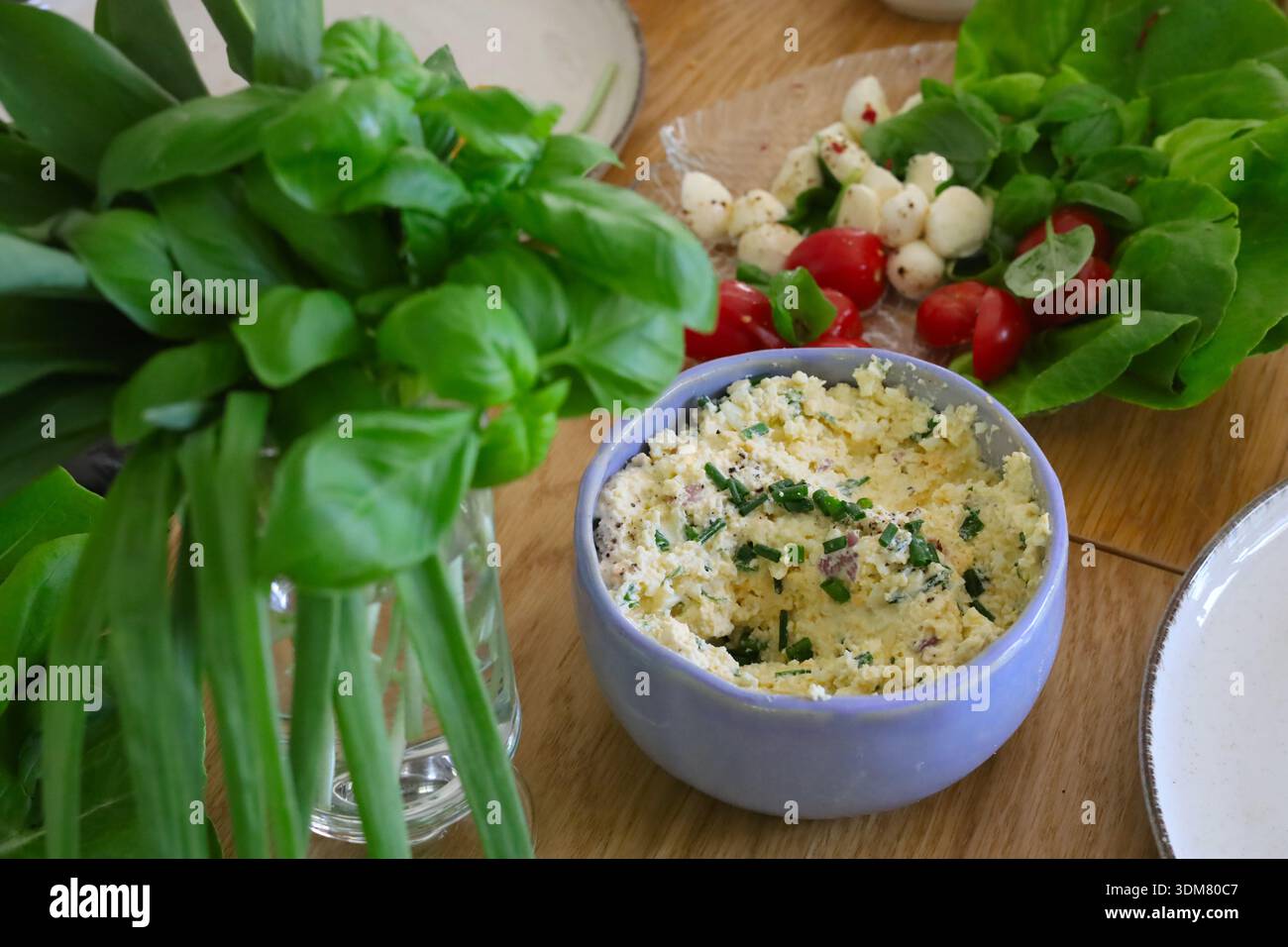 Osterfeiertage Tisch voller Speisen, einschließlich Eierpaste, Salat, Tomaten, Mozzarella, basilikum und Schnittlauch Stockfoto