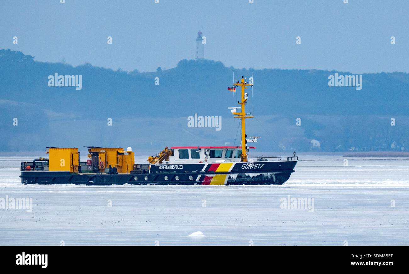 Schaprode, Deutschland. Februar 2026. Das Mehrzweckschiff und Eisbrecher „Görmitz“ vom Ostseeamt fährt durch das Eis vor der Insel Hiddensee. Das 8,68 Meter breite Schiff fährt in einem Kanal. Der Leuchtturm von Hiddensee ist im Hintergrund zu sehen Credit: Stefan sauer/dpa/Alamy Live News Stockfoto