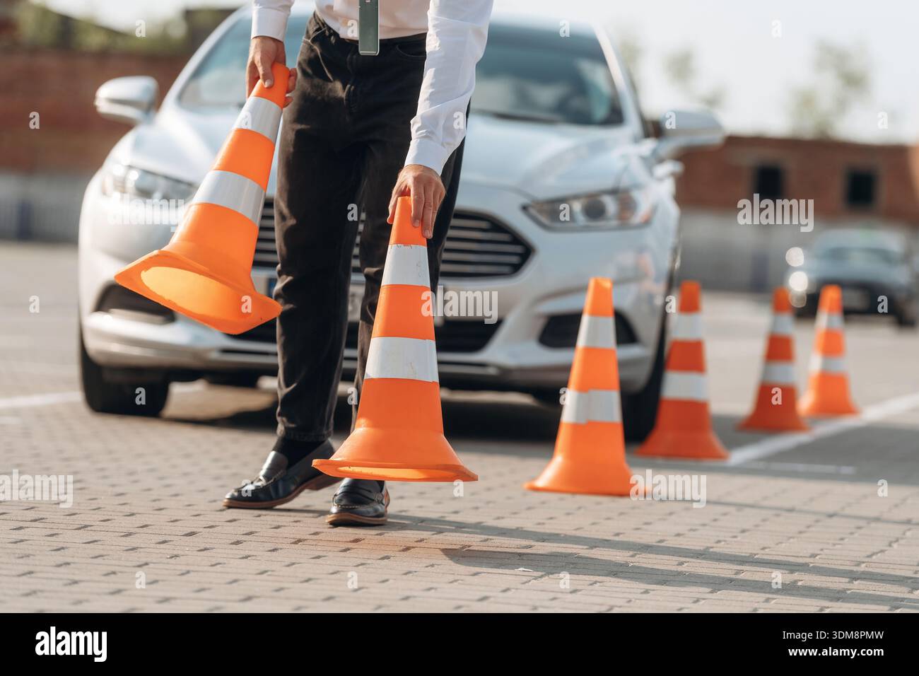 Fahrschularbeiter ist draußen in der Nähe des Autos. Stockfoto