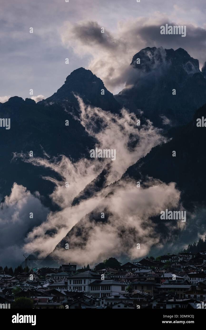 Blick auf das Dorf Auronzo di Cadore mit der Croda dei Toni, die sich über tief hängenden Wolken in der Ferne erhebt. Stockfoto