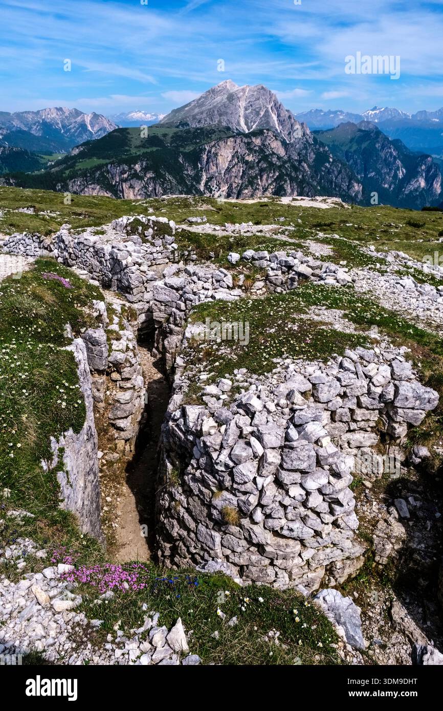 Zerstörte Gräben des Ersten Weltkriegs auf dem Monte Piana mit Dolomitengipfeln in der Ferne unter blauem Himmel. Stockfoto