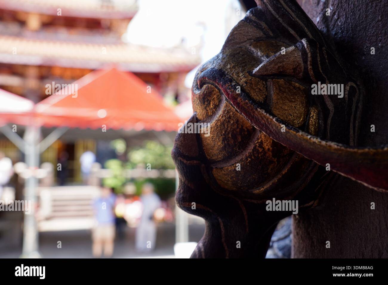 Seitenprofil einer Statue, die ein maskiertes Gesicht darstellt, das auf einer Tempelsäule in Taiwan gefunden wurde Stockfoto