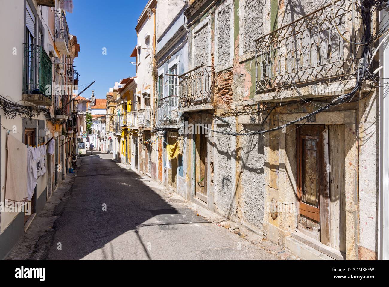Enge, traditionelle Straße im historischen Zentrum von Setubal, Portugal, mit alten Gebäuden und Wäschehängen. Stockfoto