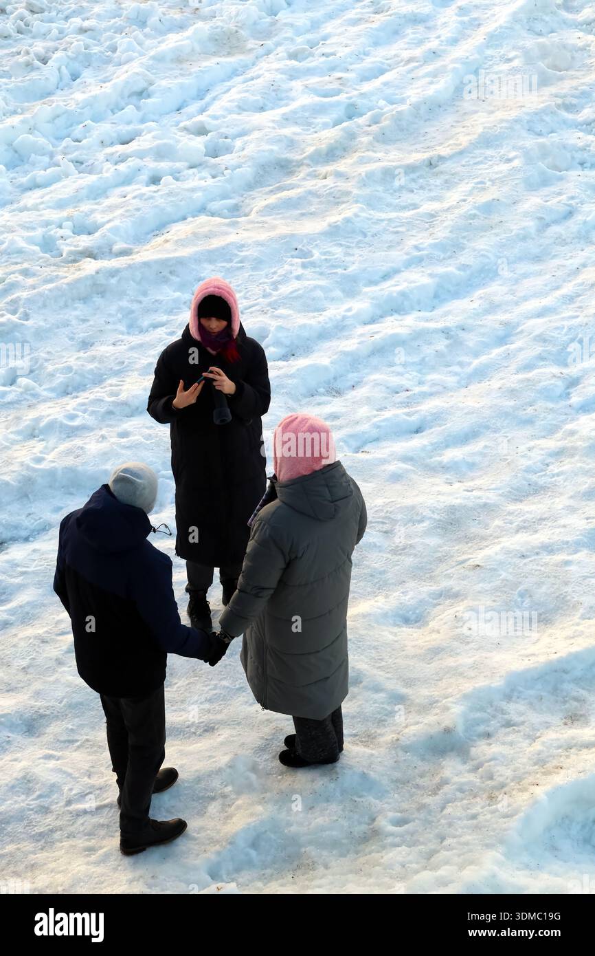 Freunde fangen den Wintermoment eines Paares im Schnee ein Stockfoto