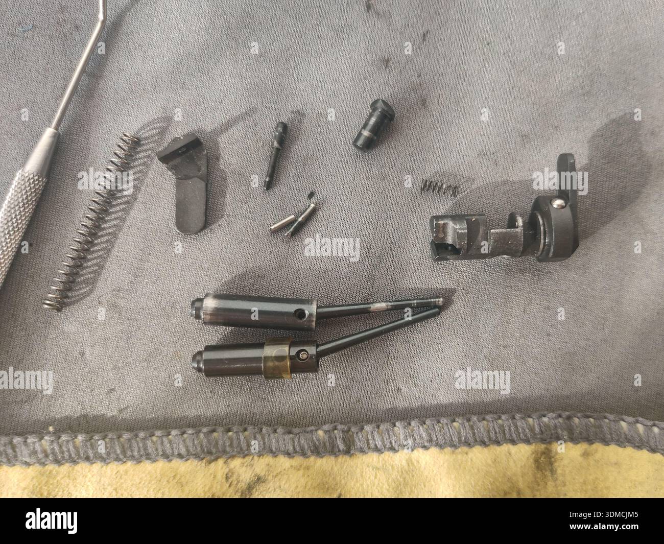 Detailansicht des Zündstifts und der Rückstoßfeder einer Schusswaffe. Demontage, Reinigung und Reparatur von Waffen Stockfoto