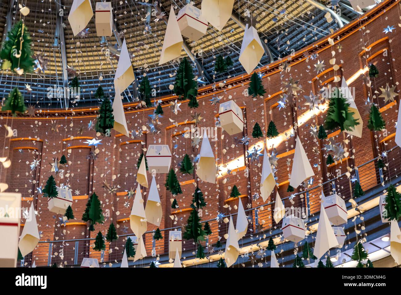 Posen, Polen – 19. November 2025: Dekorative Weihnachtsbäume aus Papier, glänzende Sterne und Gondelformen, die an einer Decke hängen und an eine Freude erinnern Stockfoto