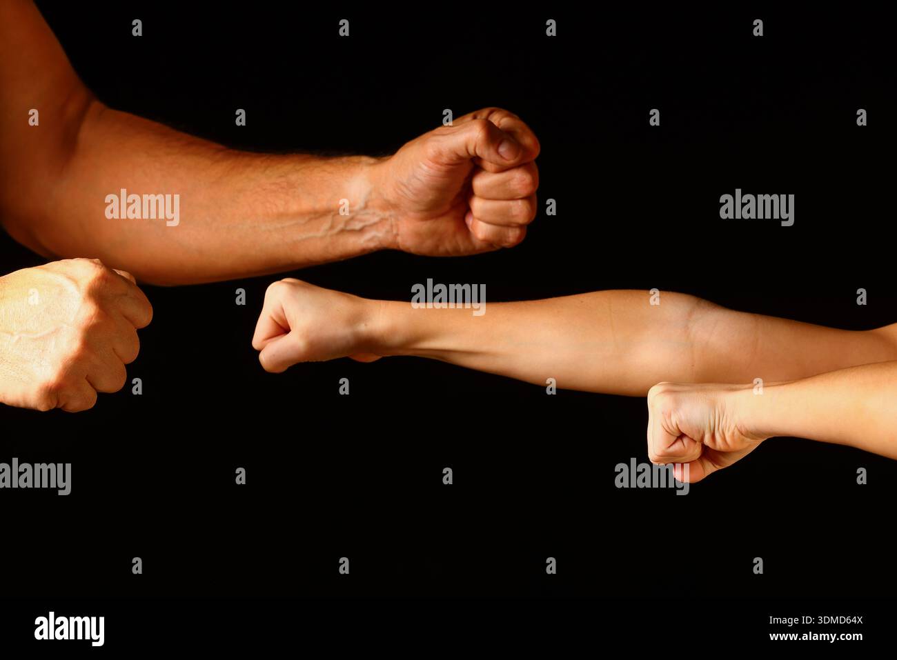 Geballte Fäuste vor dunklem Hintergrund ausgestreckt – dynamische Nahaufnahme, die Stärke, Einheit, Energie und kollektive menschliche Geste ausdrückt Stockfoto