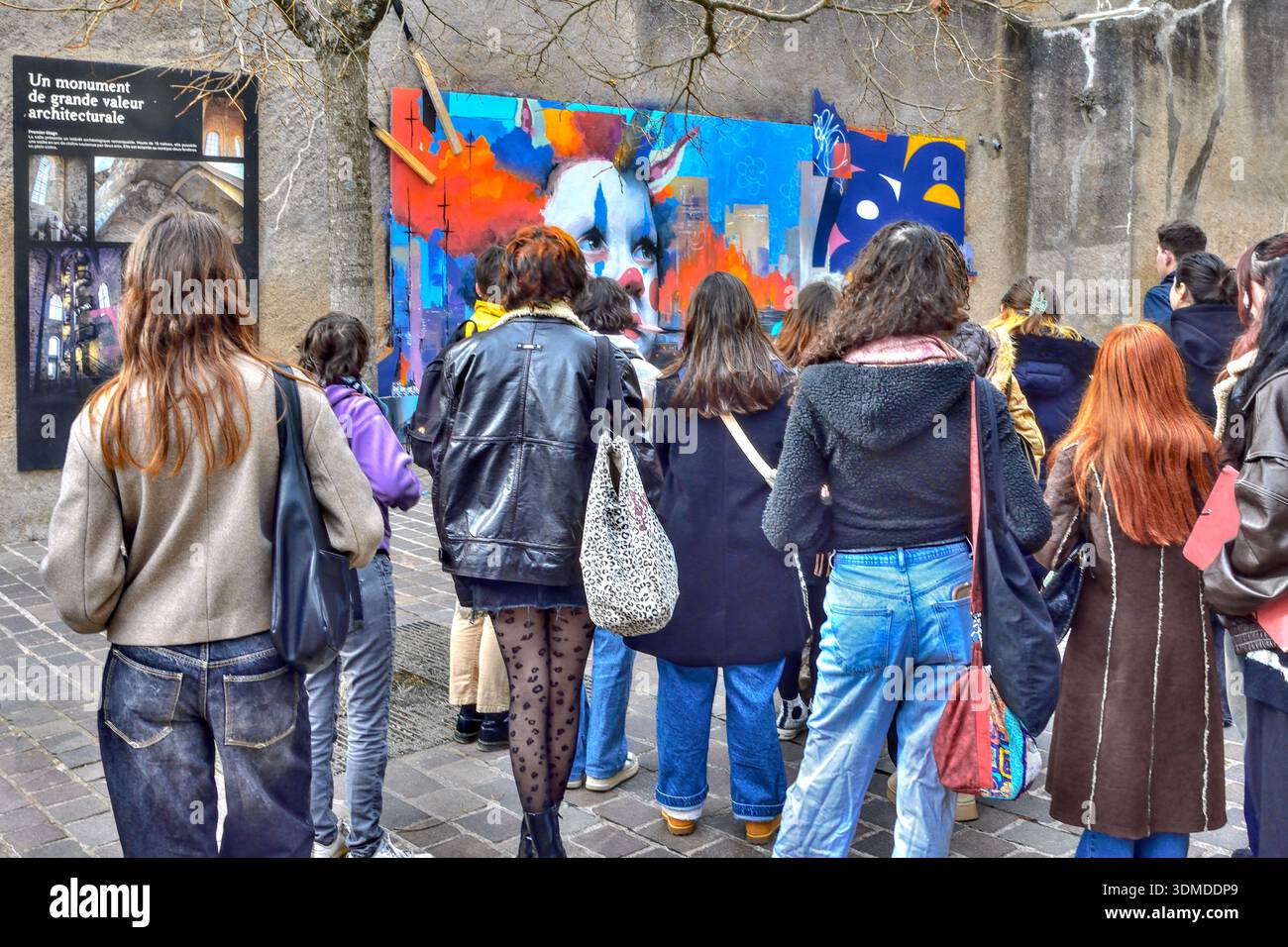 Gruppe von Kunststudenten, die das Wandbild des Clowns von Cool Kid im öffentlichen Kunstraum „Le Mur“ - Tours, Indre-et-Loire (37), Frankreich gezeigt haben. Stockfoto