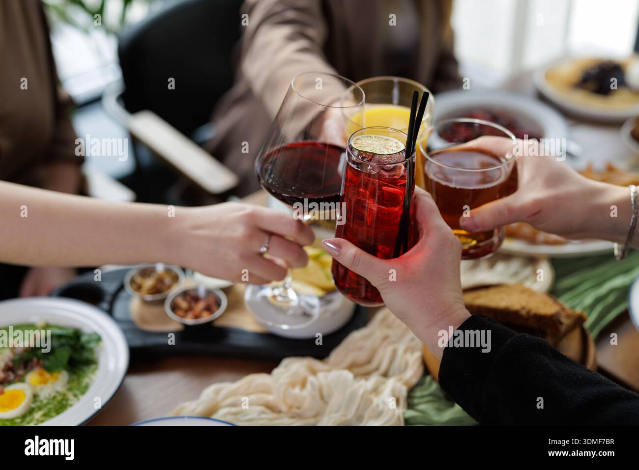 Gruppen, die Wein- und Cocktailgläser bei einer gemeinsamen Mahlzeit im Restaurant trinken. Ideal für Gastfreundschaft, sozialen Lebensstil und Feier Marketing VI Stockfoto