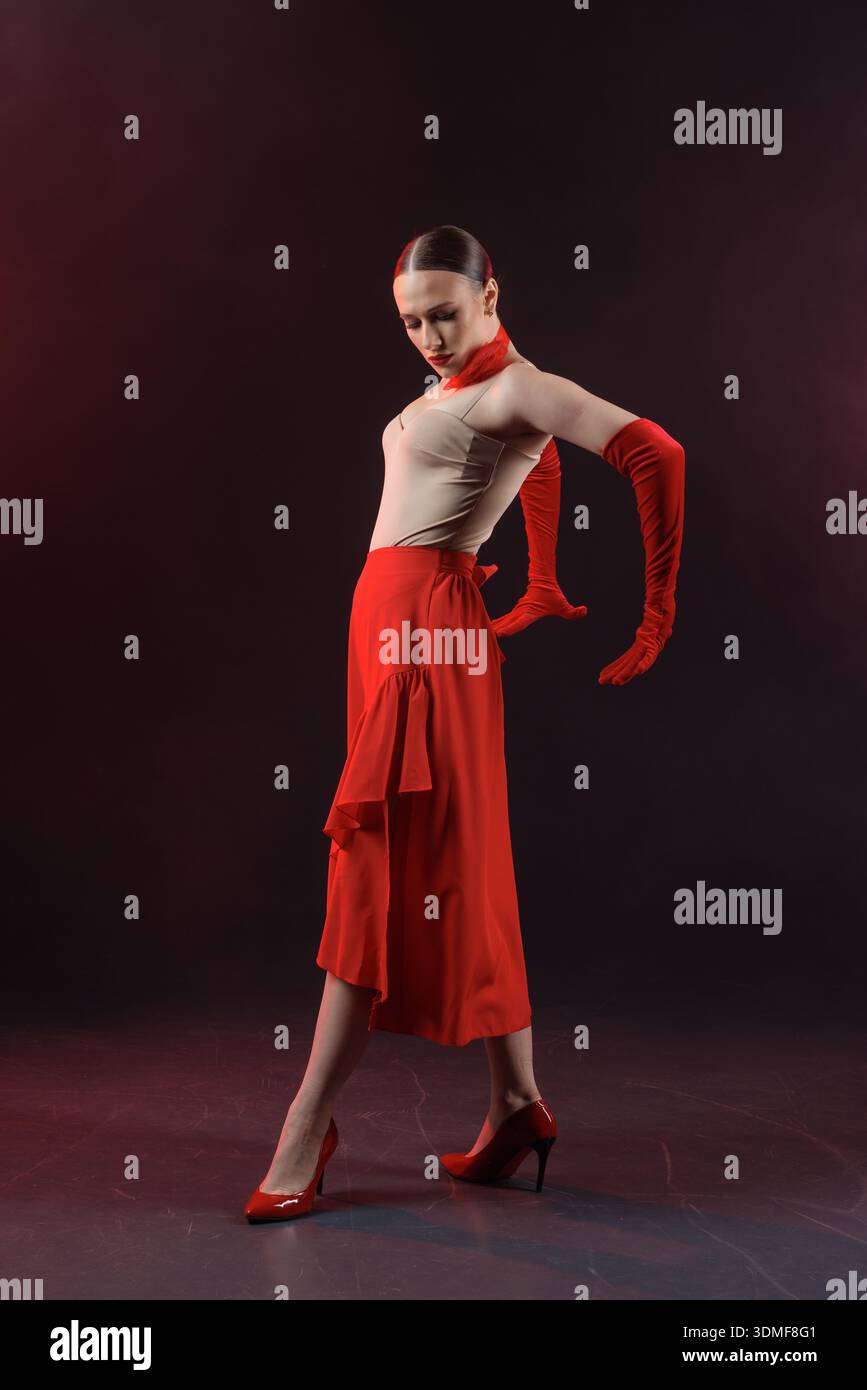 Solo-Tänzer im Ballsaal, die eine ausdrucksstarke, kontrollierte Pose in einem Studio-Setting aufführt. Geeignet für Werbebanner, Websites und visuelle Inhalte Stockfoto