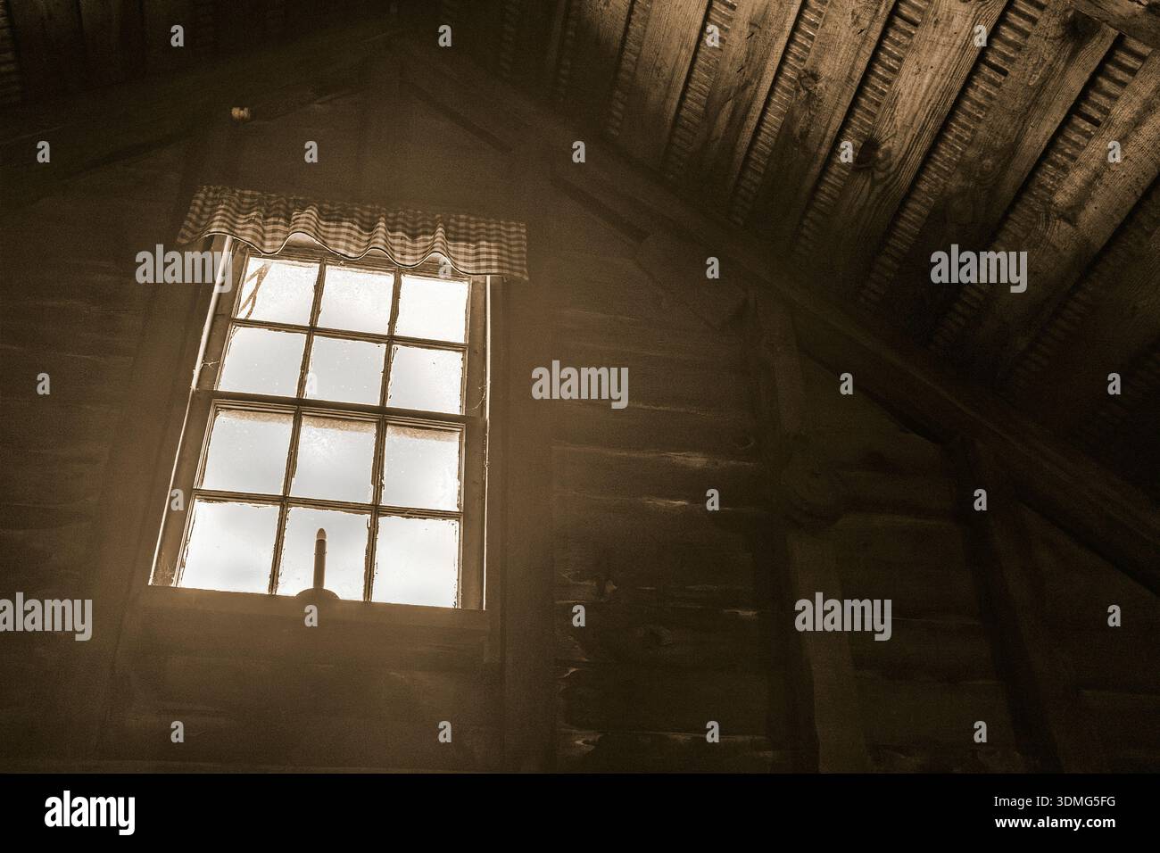 Flacher Blick auf das Dachfenster mit elektrischem Kerzenhalter auf der Fensterbank in einer rustikalen Scheune Stockfoto
