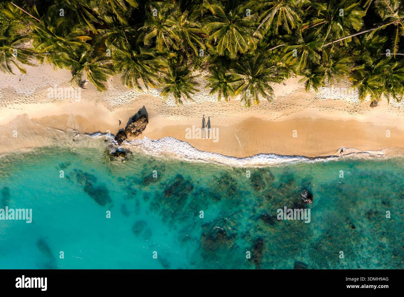 Entdecken Sie die atemberaubende Schönheit des Takhian Beach auf Koh Kood, Thailand. Ein paar Männer und Frauen laufen während des Urlaubs am Strand Stockfoto