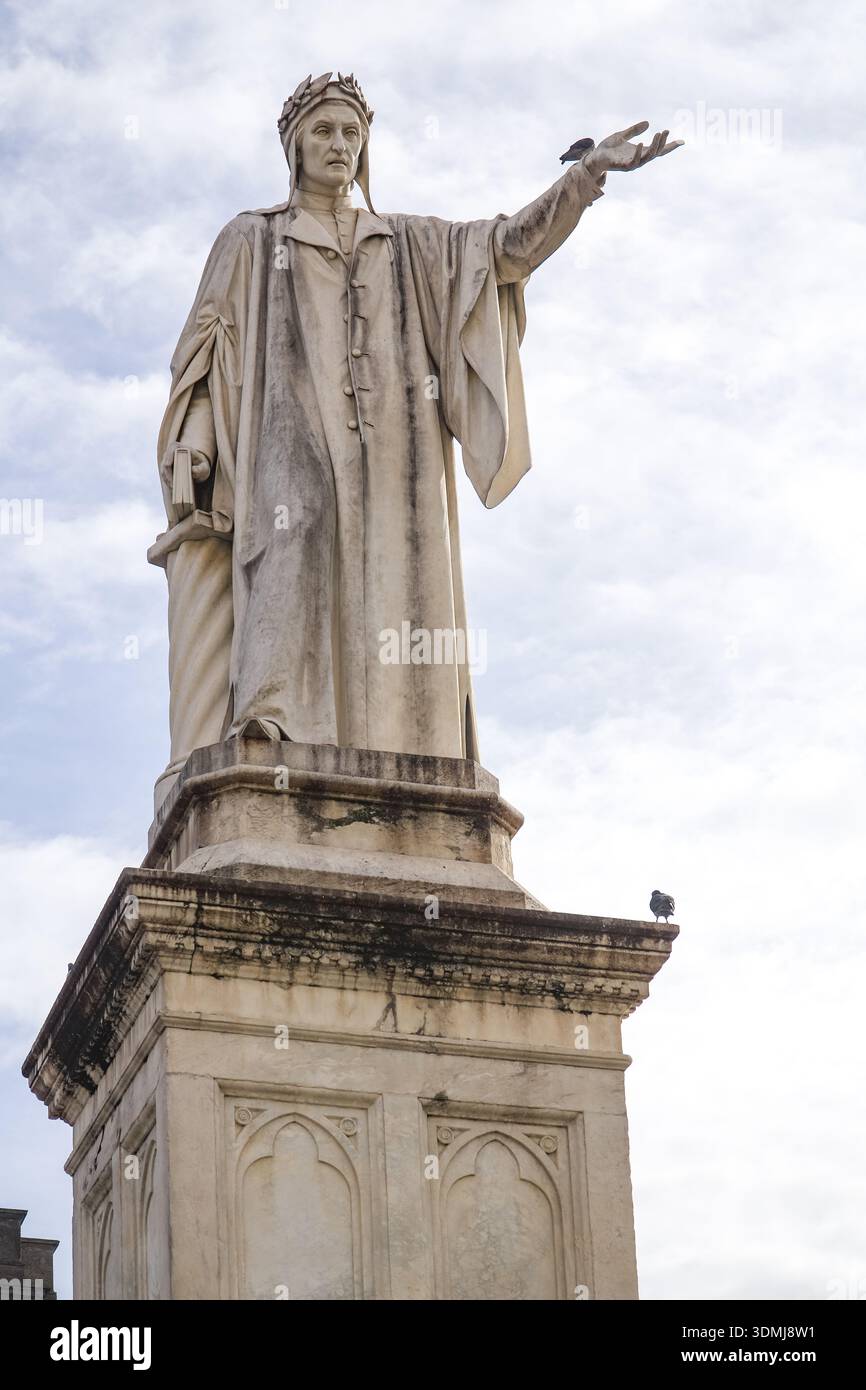 Statue von Dante Alighieri (Dante Alighieri) auf der Piazza Dante, Neapel, Kampanien, Italien. Historisches Denkmal zu Ehren des Dichters, vor bewölktem Himmel. Stockfoto