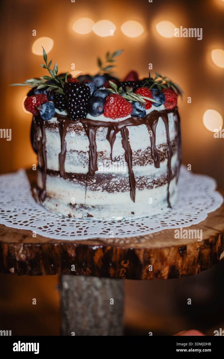 Einstöckiger Kuchen mit Schokolade, getropft mit Beeren Stockfoto